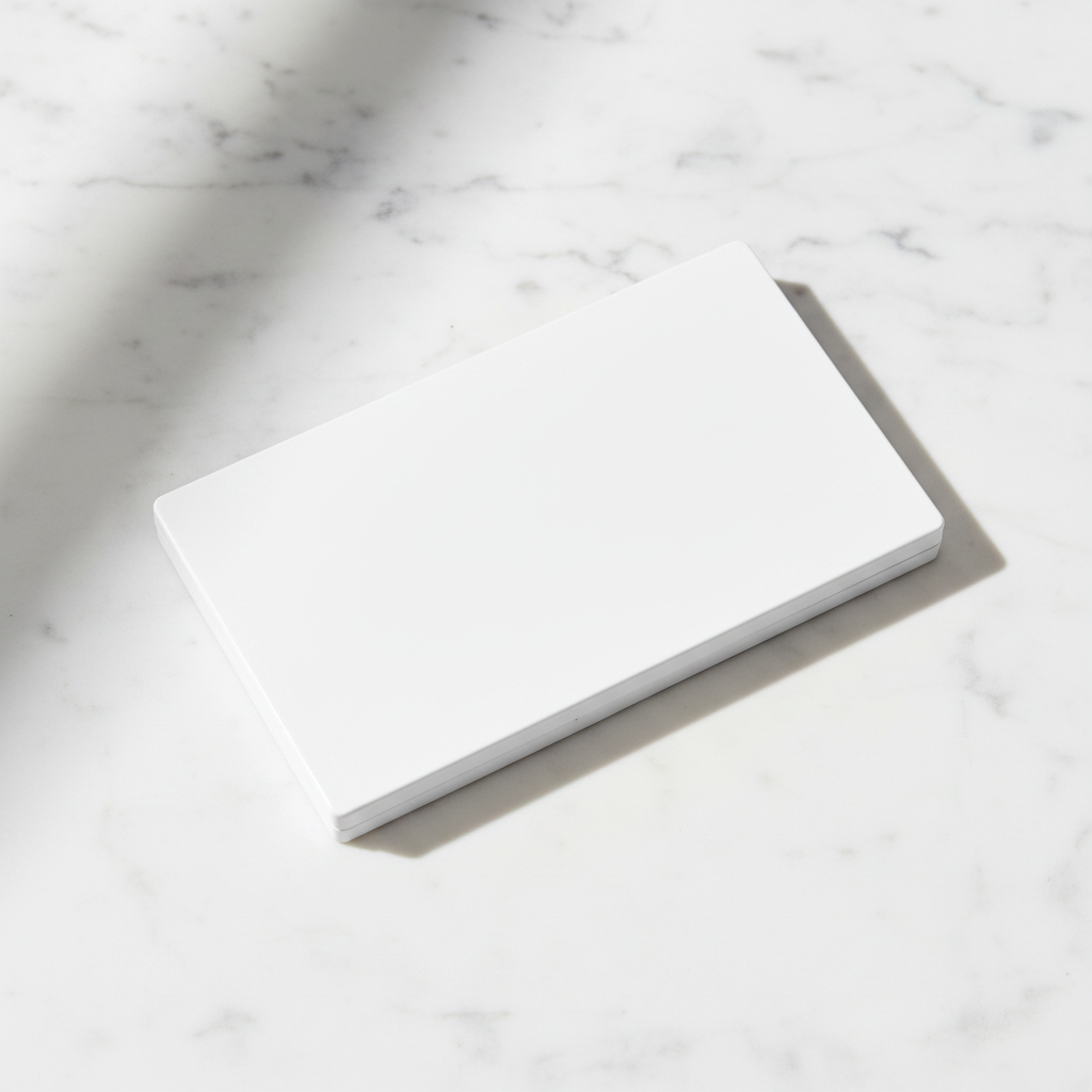 Matte white rectangular 8-pan eyeshadow palette closed showing clean minimalist exterior on marble surface