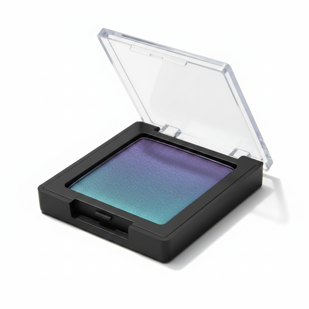 45-degree angle side view of square black compact with clear flip lid open showing violet teal duochrome shimmer eyeshadow
