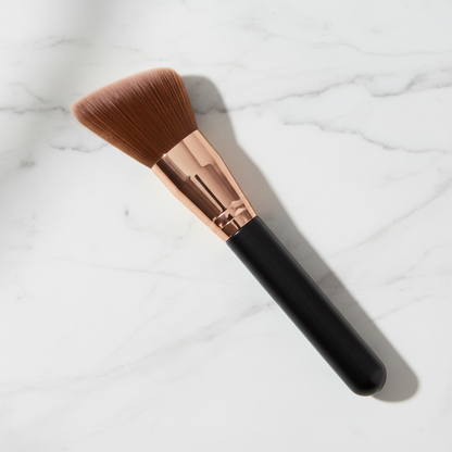 Top-down flat lay view of angled flat-top contour brush on marble surface