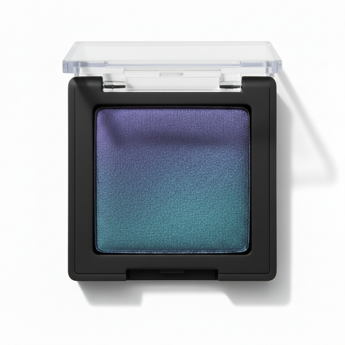 Square black compact with clear lid open showing violet purple to teal green duochrome gradient shimmer eyeshadow