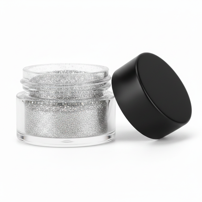 Close-up of open clear glass jar with matte black lid removed showing holographic silver glitter powder texture inside