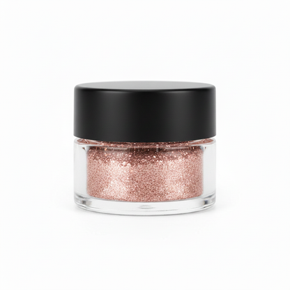 Clear glass jar with matte black lid filled with rose gold pink fine glitter eyeshadow powder