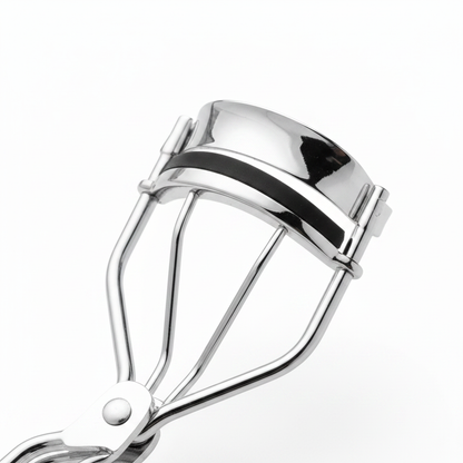 Close-up of polished silver eyelash curler clamp head showing curved arc, black silicone pad and center rivet hinge